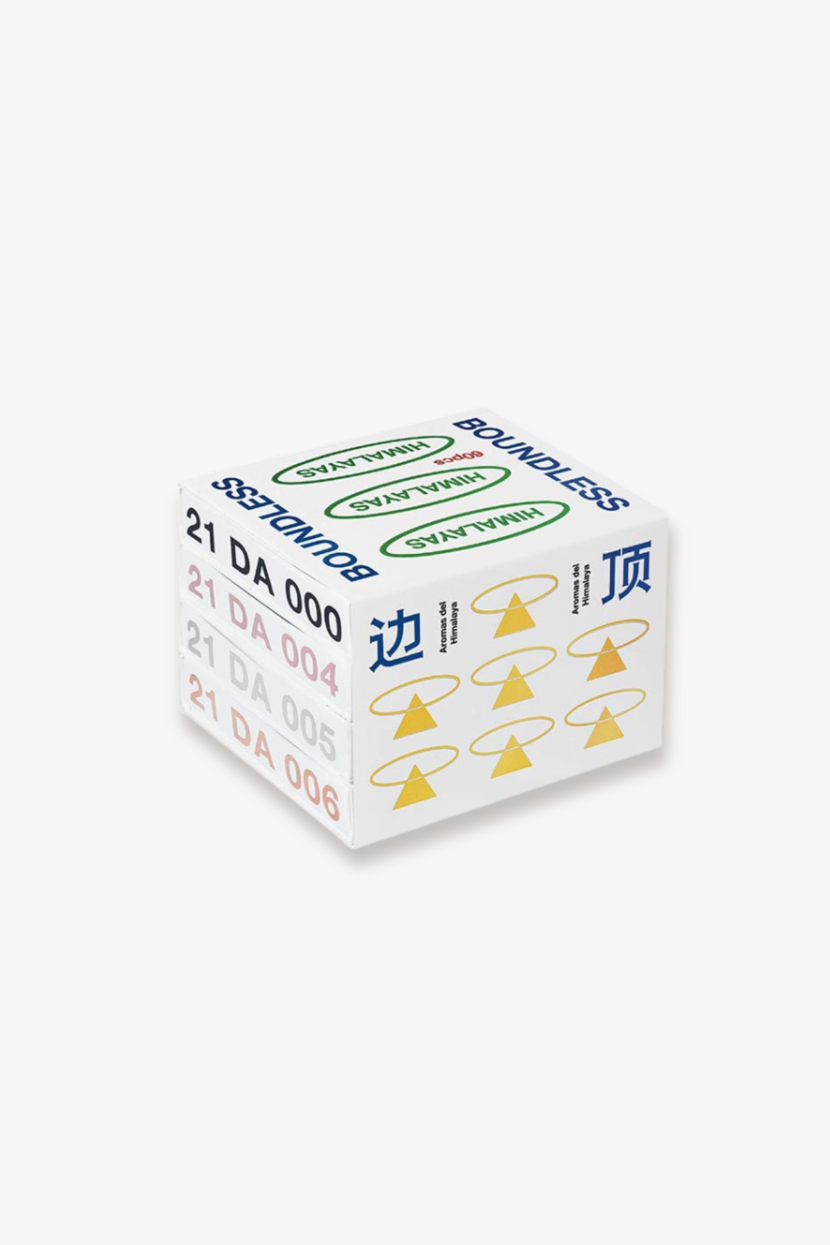 Three boxed scented incense products arranged on a brown wooden surface, with a woven cane chair back in the background. The boxes are white with printed text and symbols; one box reads 'BOUNDEDLESS' and the others show incense stick details and 'Herbal Incense From the Himalayas'.