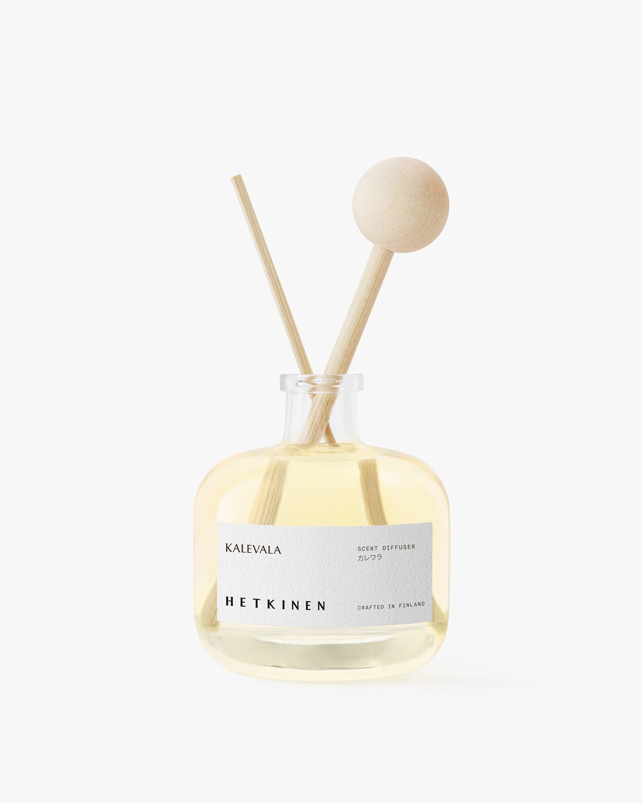 Diffuser bottle with wooden sticks labeled 'Happy Holidays' by 'Hetkinen' on a white background