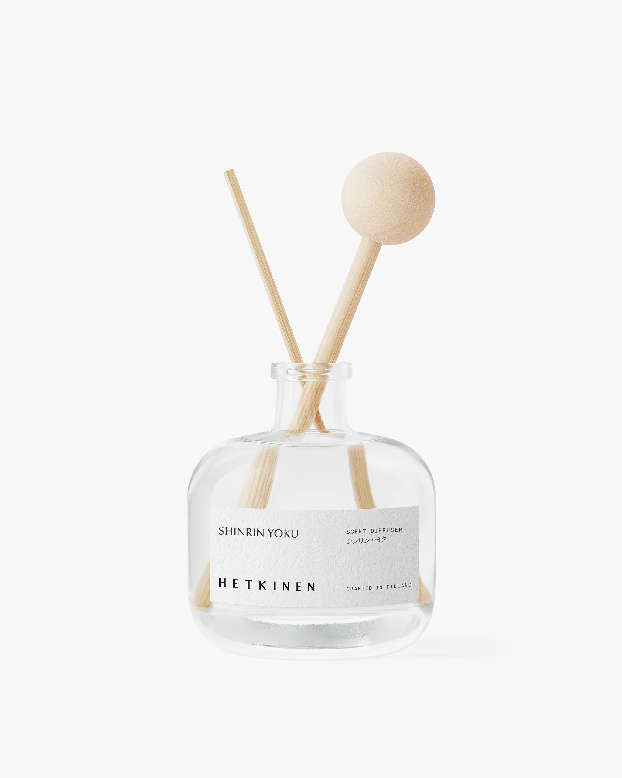 Clear glass diffuser bottle with wooden sticks labeled 'Pine Forest' by 'Hetkinen' on a white background